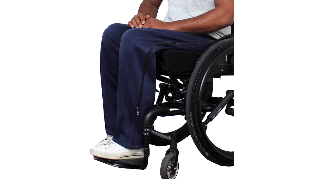 Ein Mann sitzt in einem Rollstuhl und trägt die bequeme Hose mit den Reißverschlüssen entlang der Beine.