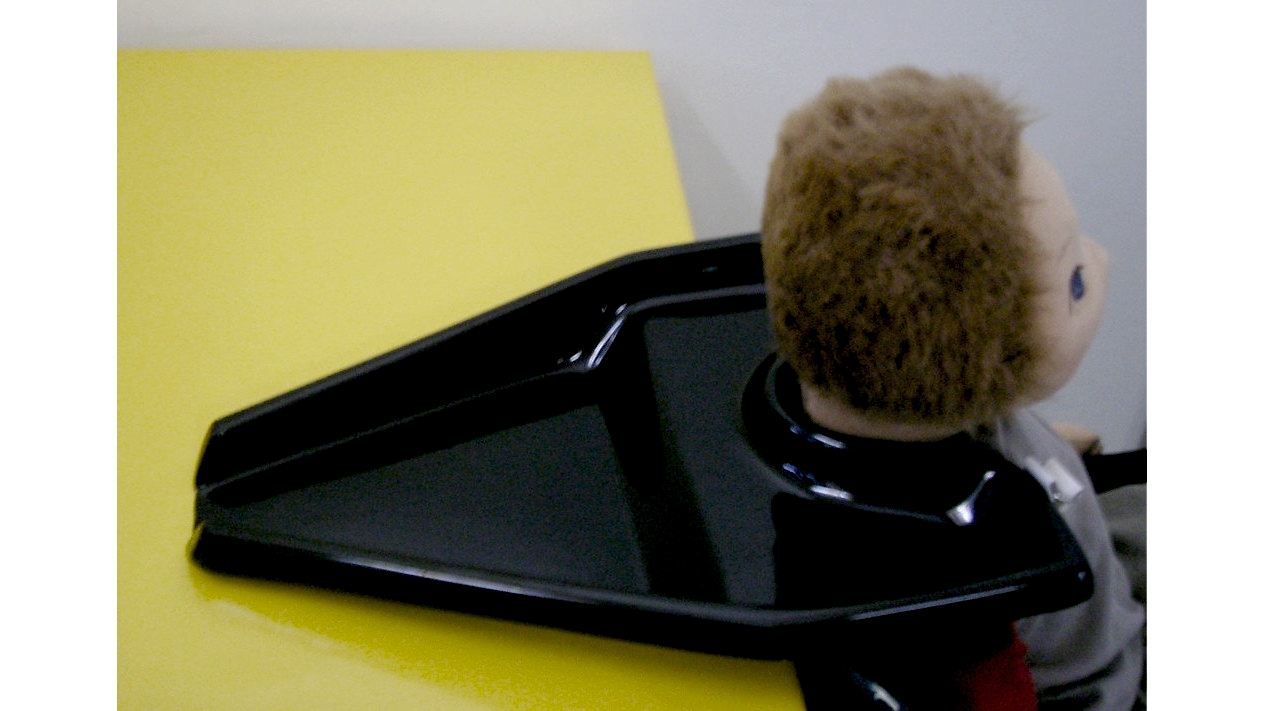 Ein Haarwaschbecken als Aufsatz mit rundem Ausschnitt für den Hals, hier mit einer Puppe demonstriert
