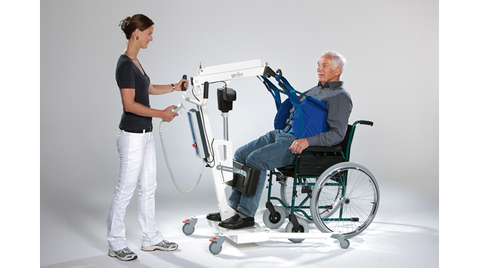 Mit Hilfe eines Patientenlifters wird eine Person aus dem Rollstuhl gehoben.