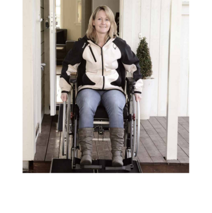Eine Frau verlässt das Haus im Rollstuhl.