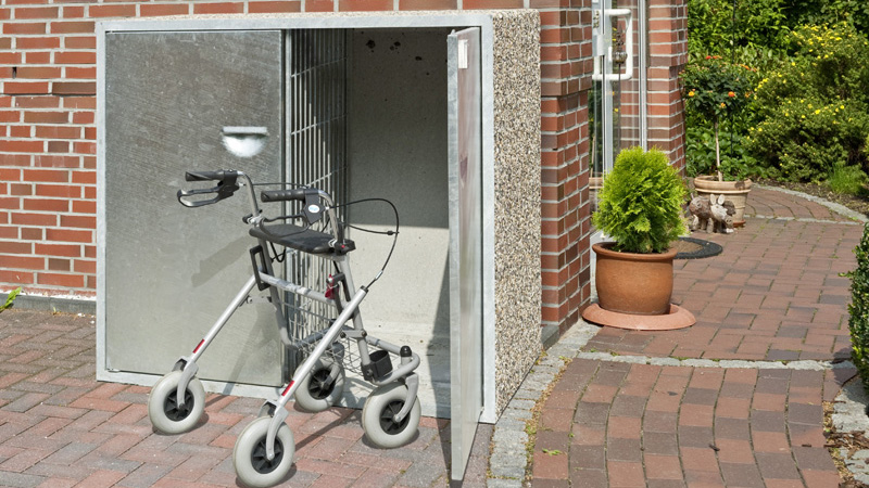 Außenbox mit zwei getrennten Bereichen. Eine Tür steht offen, vor ihr steht ein Rollator.