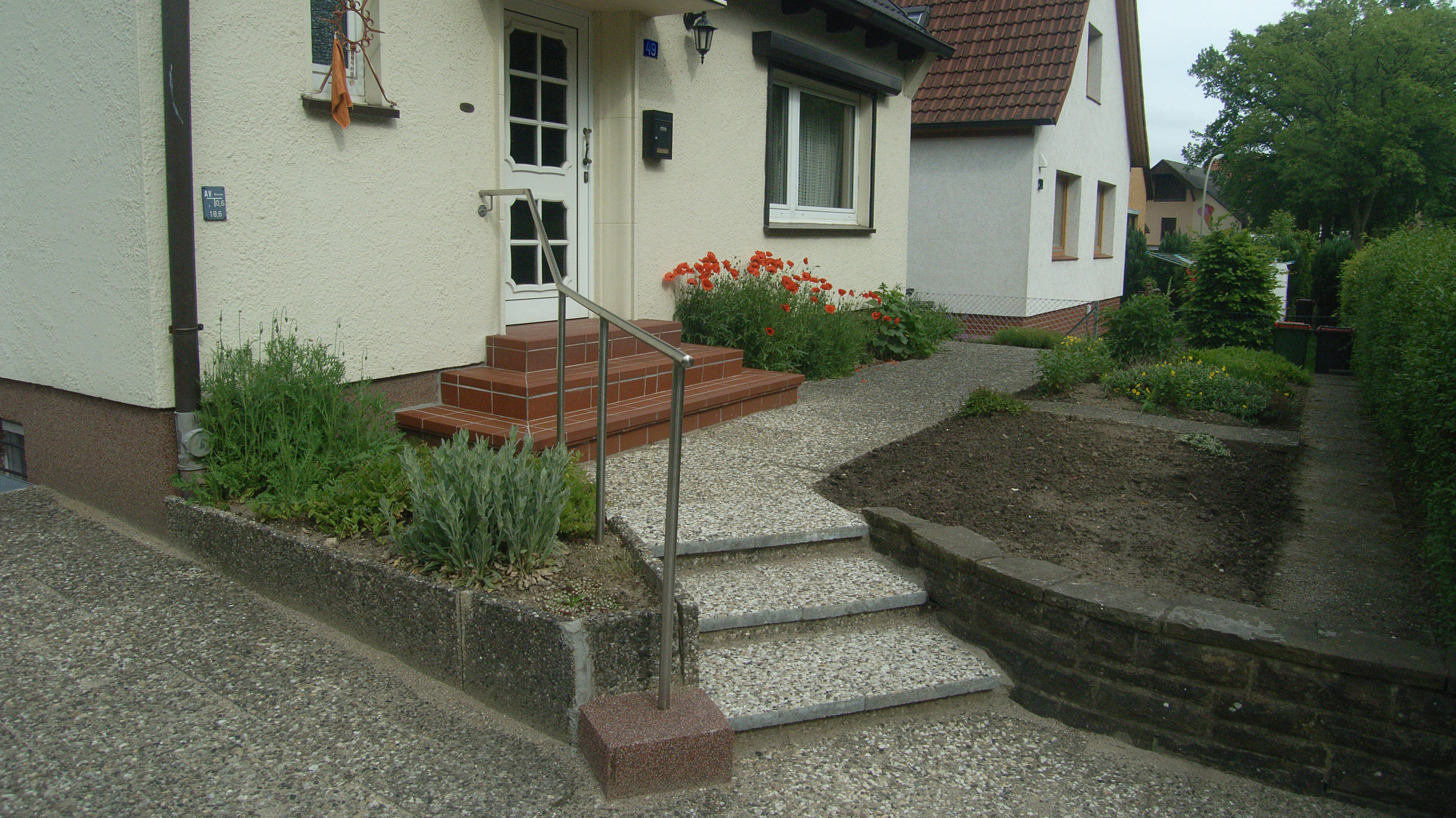 Die Haustür eines Einfamilienhauses, welche nur über Treppen zu erreichen ist.