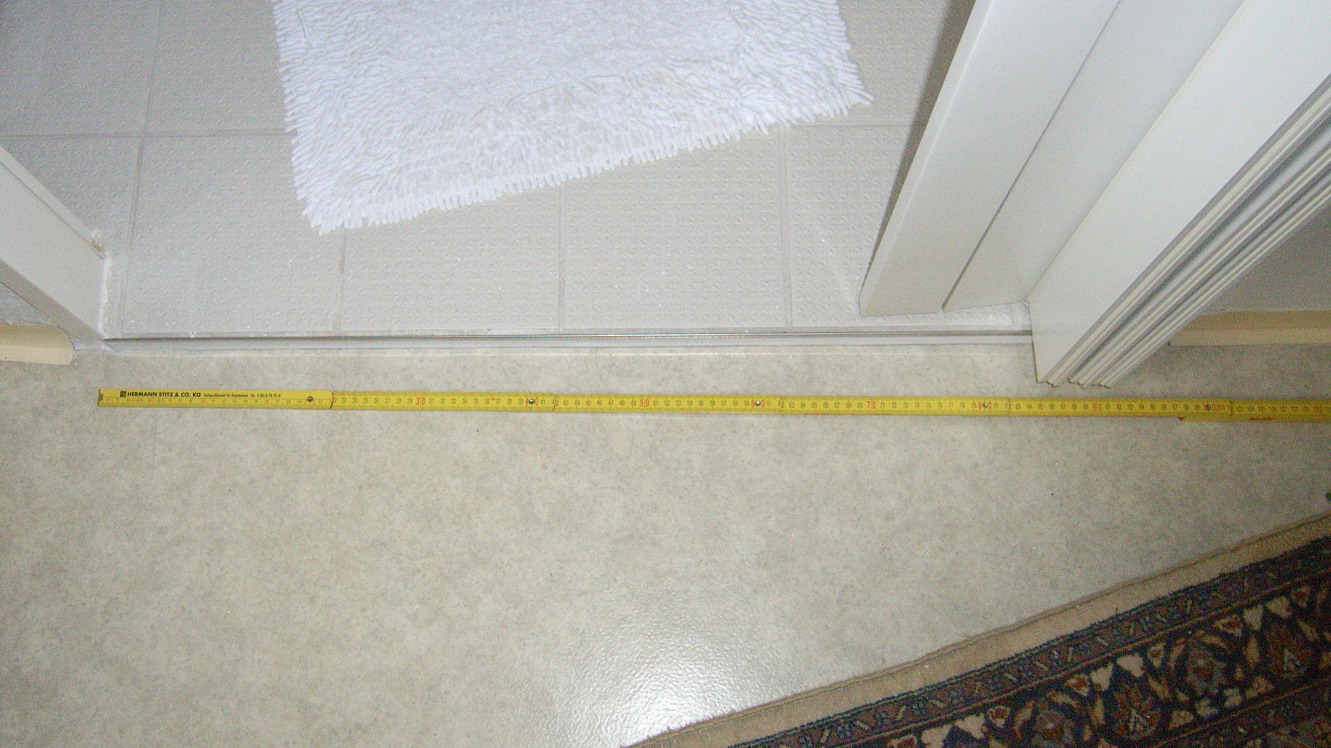 Zur Messung der Türbreite liegt ein Zollstock neben der Türschwelle am Boden.