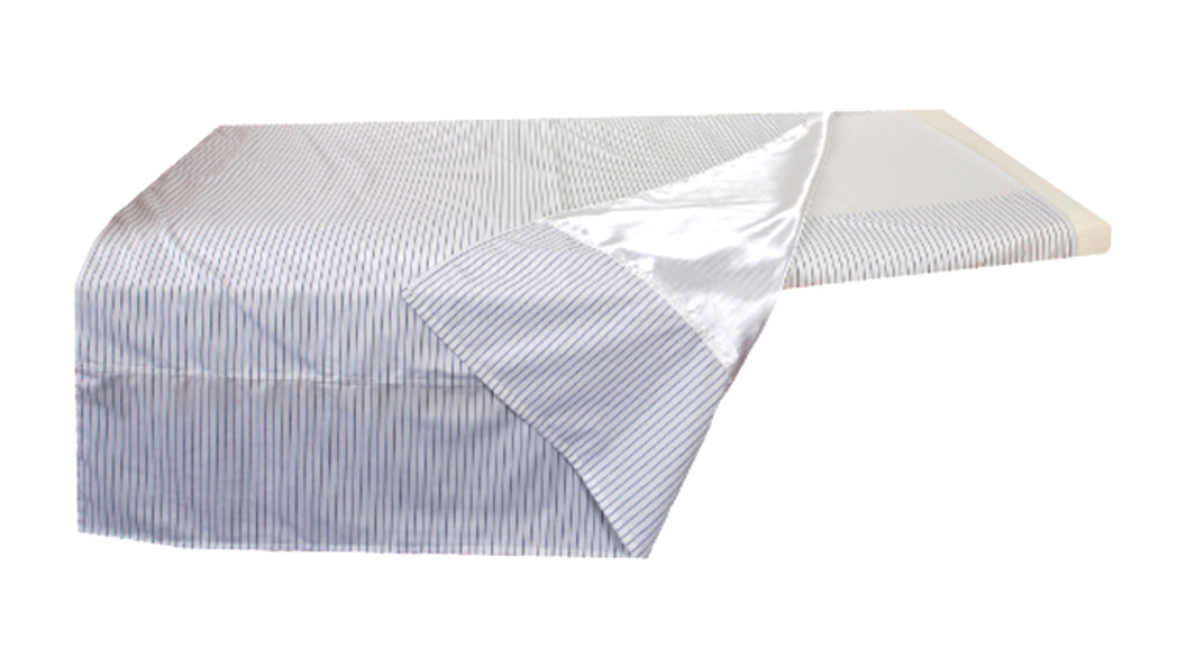 Ein Wendelaken mit glatter Unterseite auf einer Matratze