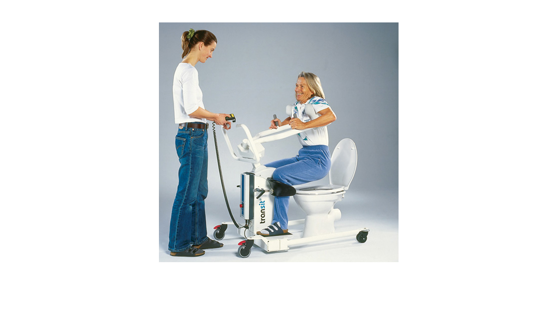 Eine Frau wird mit einer Umsetzhilfe über das WC bewegt.
