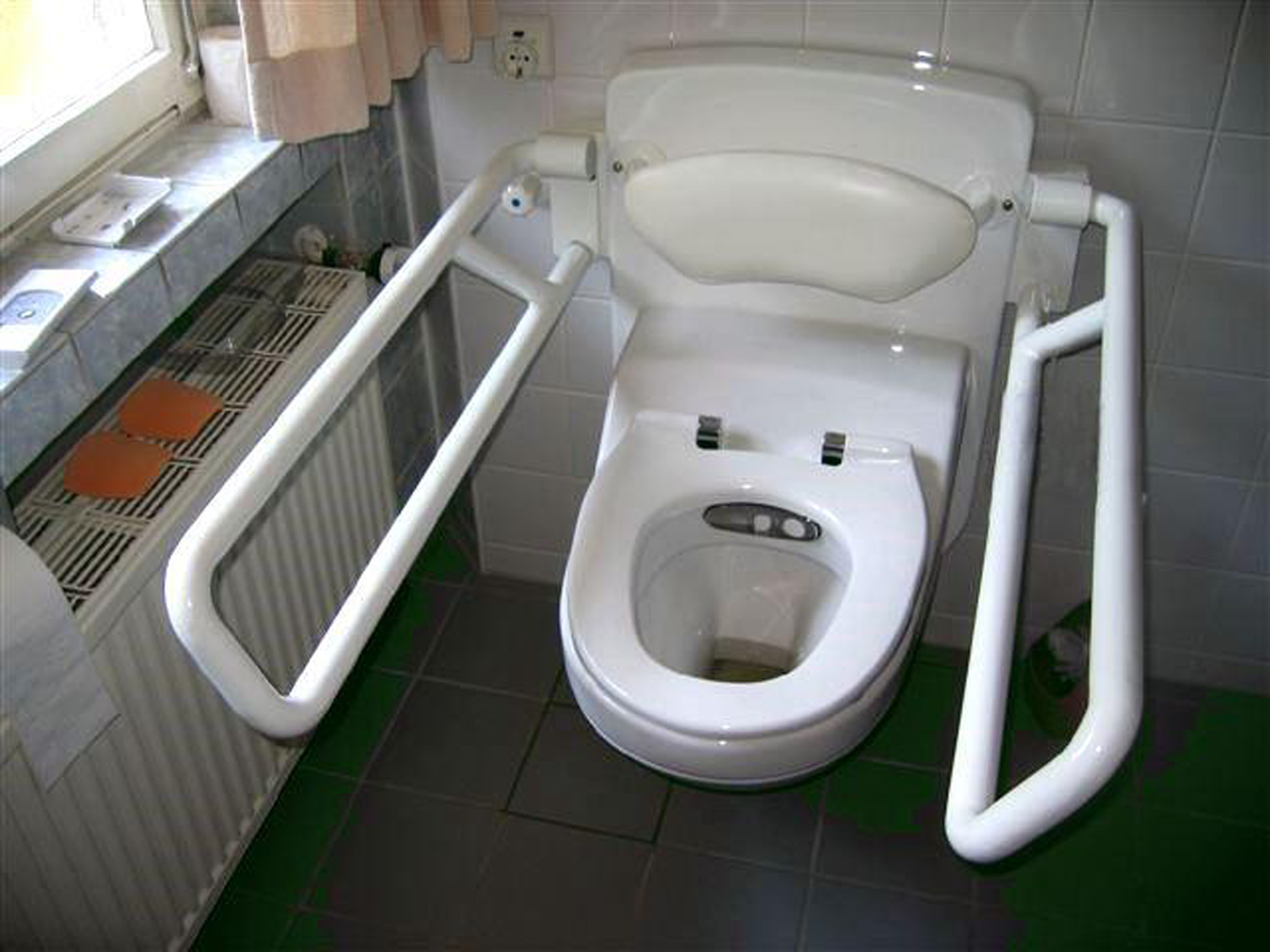 Lift Toilette CarePlus elektrisch höhen- und neigungsverstellbare Lift Toilette mit Stütz-Klapp-Griffen.