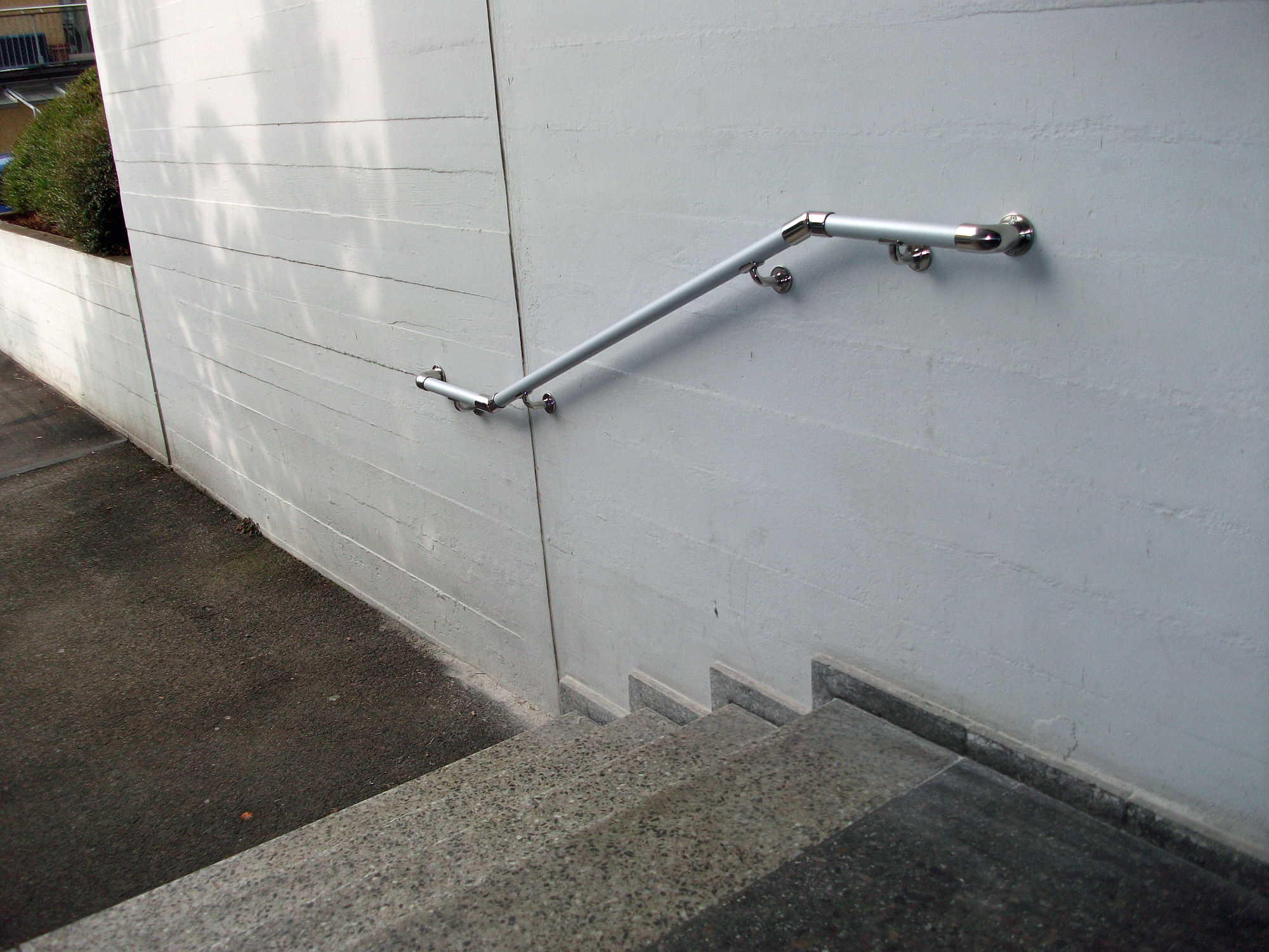 Beispiel: Außentreppe mit an der Hauswand befestigtem Handlauf.