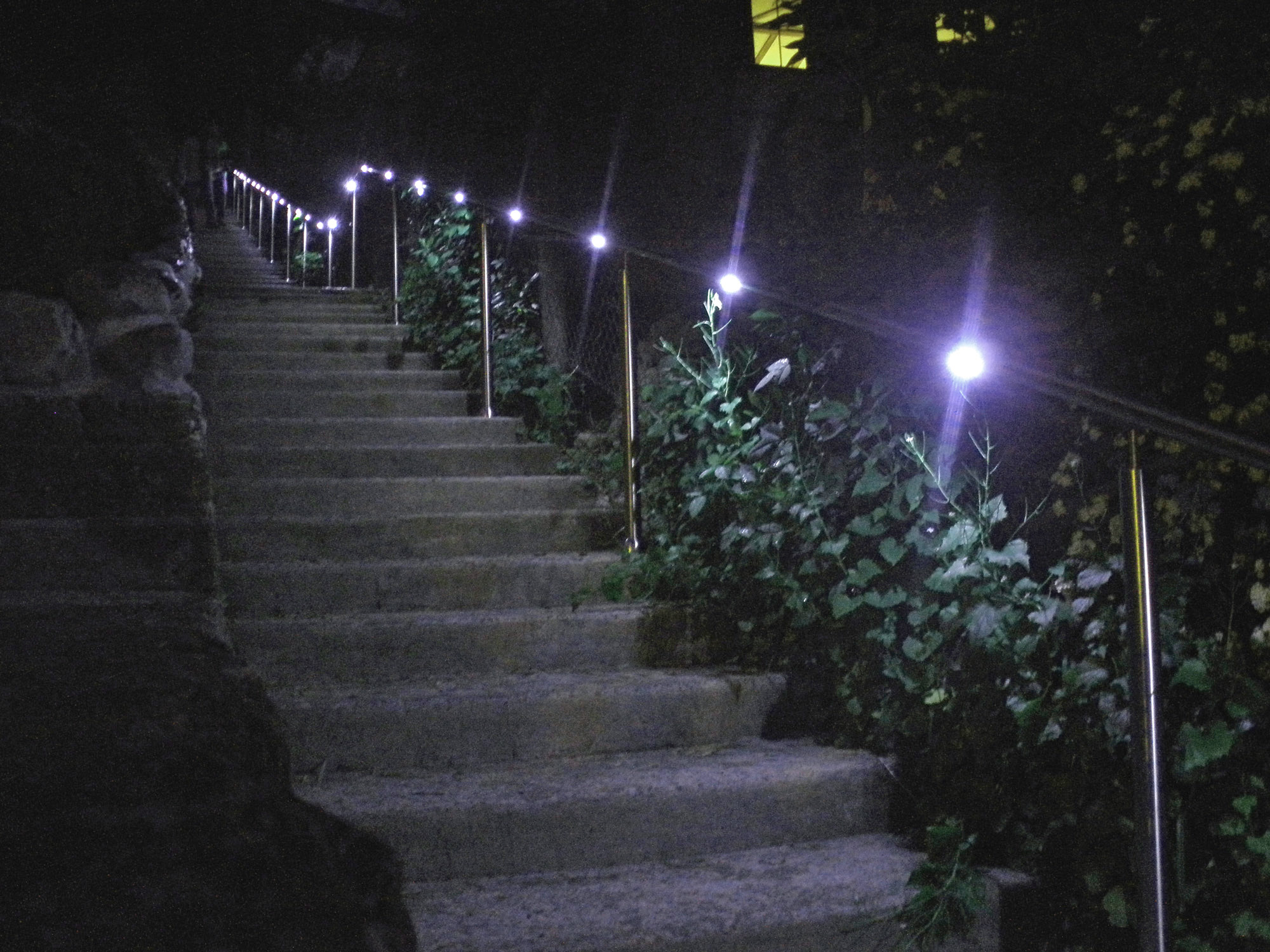 Beispiel: Lange Treppe im Freien mit beleuchteten Außenhandlauf.