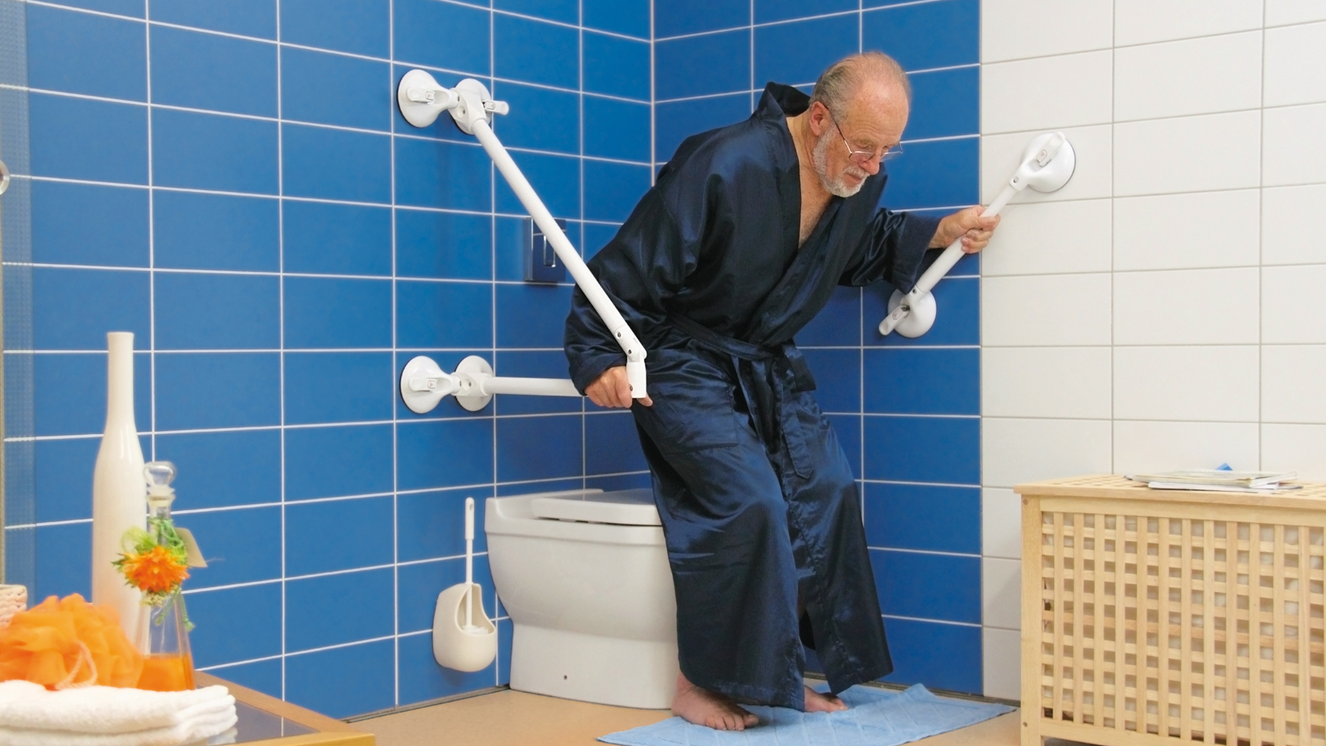 Ein Mann zieht sich mit Hilfe eines mobilen Haltegriffes aus der Badewanne.