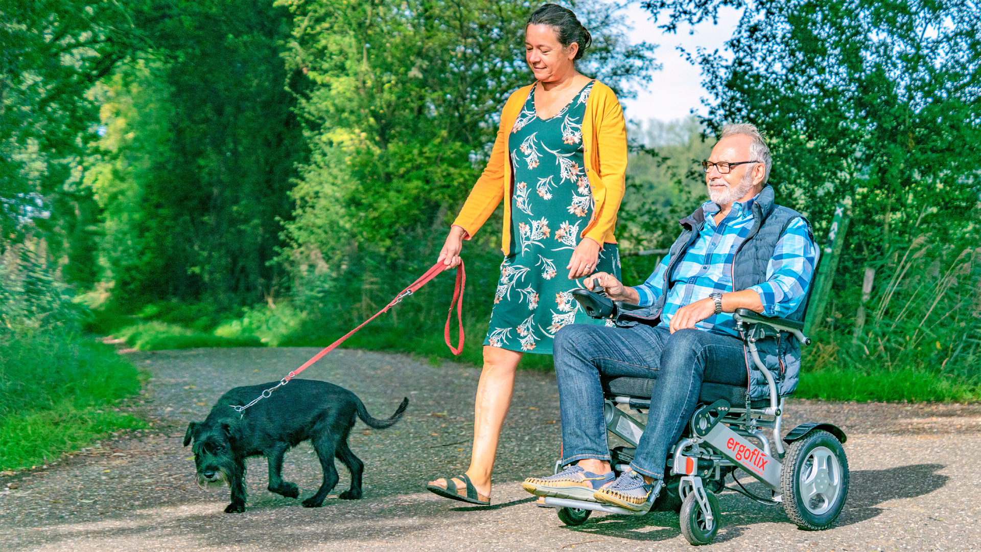 Mobile Lebensfreude - Ein Paar, unterwegs mit Rollstuhl und Hund.