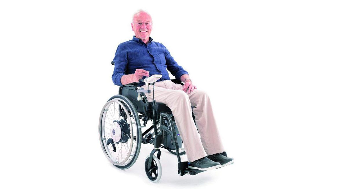 Eine Person unterwegs im Rollstuhl mit Zusatzantrieb.