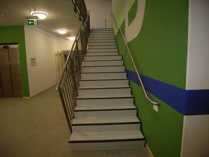 Markierte Stufen, Podest auf der mittleren Treppenhöhe und beidseitiger Handlauf.