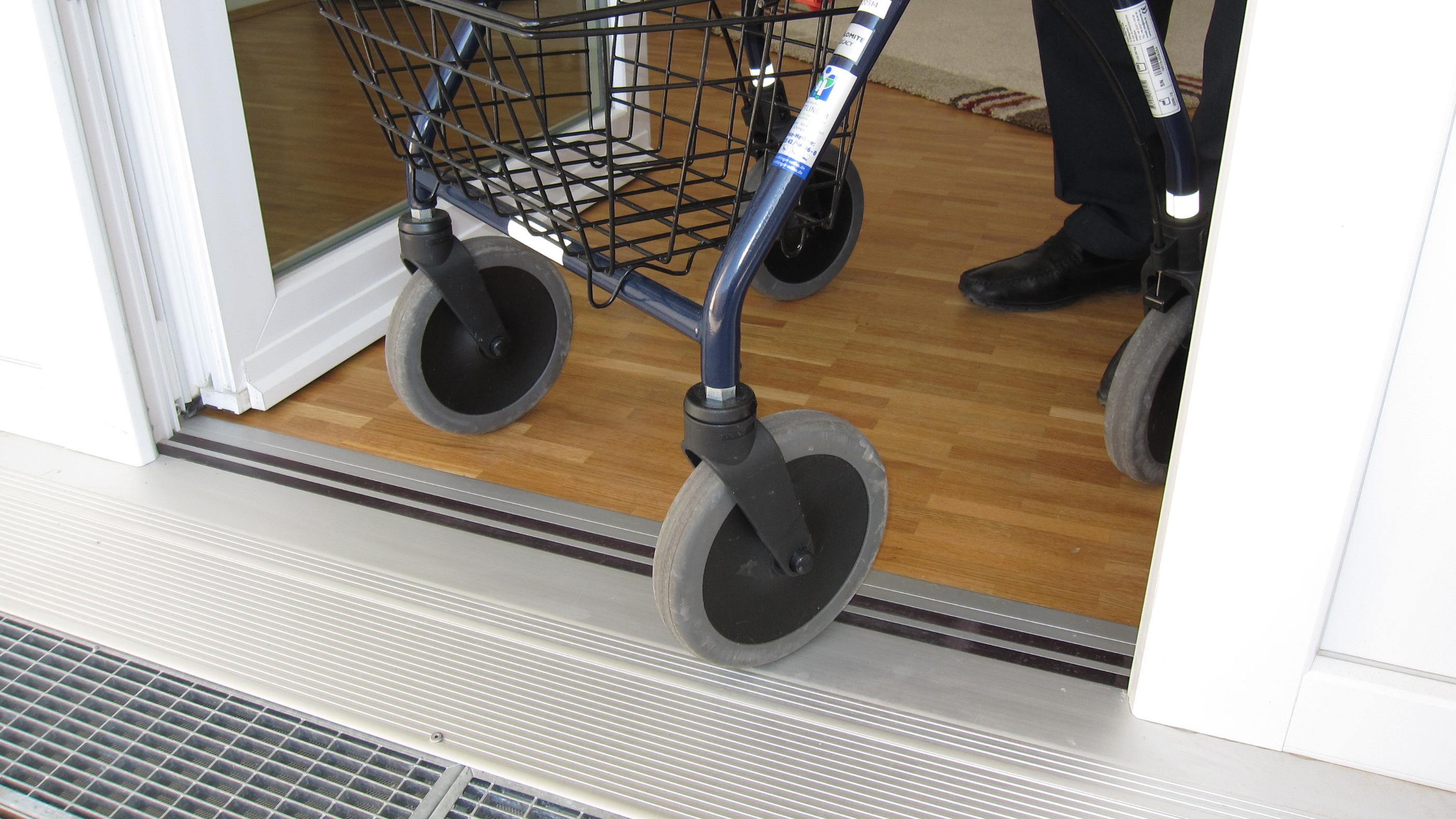 Eine Person mit Rollator fährt über die Terrassentür ohne Türschwelle
