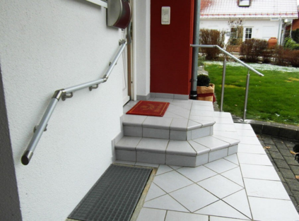 Ein Wandhandlauf und ein freistehender Handlauf für zwei Stufen vor dem Hauseingang.