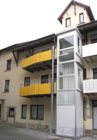 Senkrechtaufzug außen an einem Gebäude mit mehreren Wohnungen. (Bild HIRO LIFT)