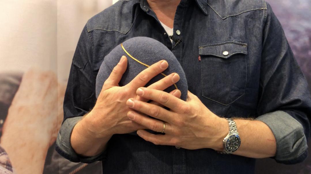 Ein Mann hälte das Klangkissen inmu mit beiden Händen vor seiner Brust.