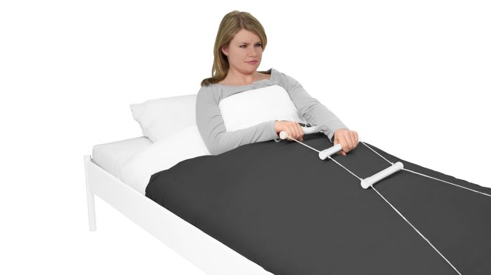 Ein Frau richtet sich im Bett mit einer Strickleiter auf.