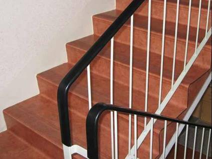 Treppe mit rutschhemmendem Bodenbelag und einseitigem Handlauf.