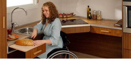 Rollstuhlfahrerin in einer barrierefreien Küchen